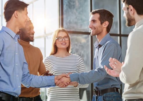 friendly hr manager or team leader greeting or welcoming new worker