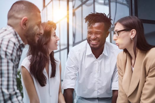 Diverse business groups stand around a meeting table.