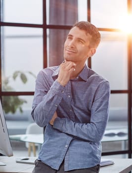 Serious thoughtful millennial business man looking away, thinking over creative ideas for project, making