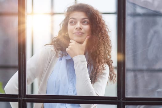 from behind the glass. young business woman thinking about something