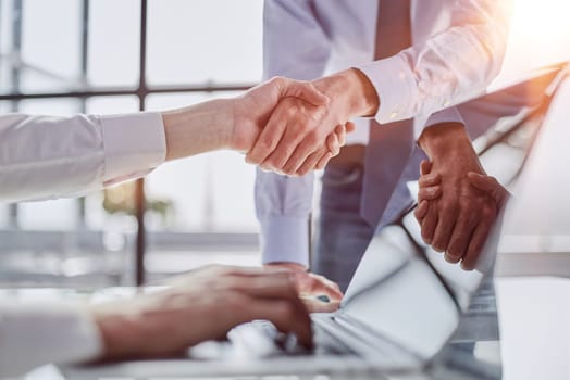 business handshake concept, partners shaking hands over office desk,