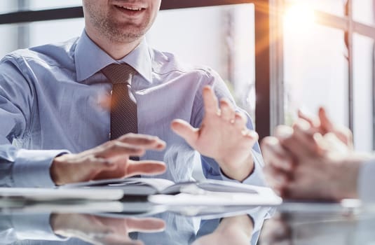 Two business men sit at desk discuss project details