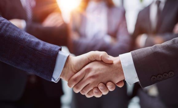 businessmen shaking hands starting teamwork partnership standing in corporate work space hallway