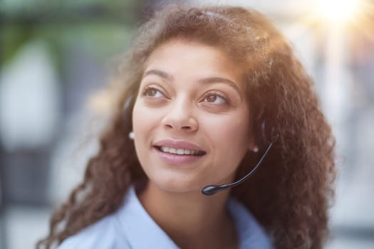 Beautiful smiling woman consultant in headphones with a microphone. Remote work from home.