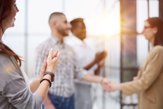 business woman rejoices at the success of her colleagues while standing in the conference room