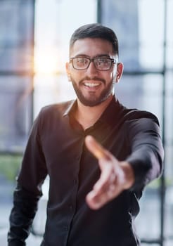 smiling businessman reaching out for a handshake