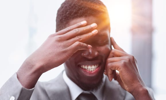 Portrait of a happy confident young african american businessman standing with his arms crossed looking at camera