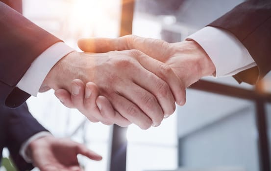 Handshake of two businessmen in a conference room, close-up