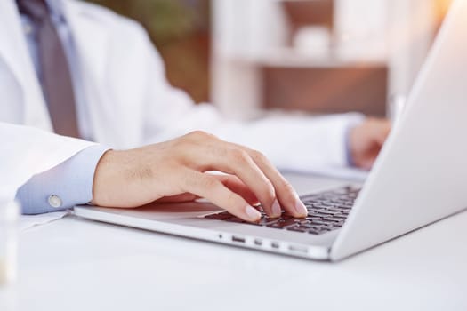 Typing on computer keyboard, doctor using modern technology at work