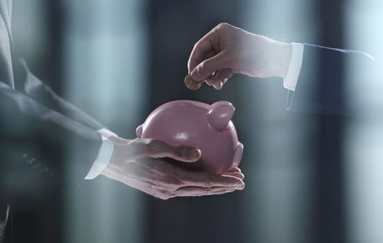 Hand puts a coin in a piggy bank on a black background. accumulation concept