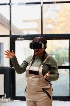 African american employee working at goods inventory using virtual reality headset in storage room. Warehouse worker preparing packages for delivery, using 3d simulation for customers orders