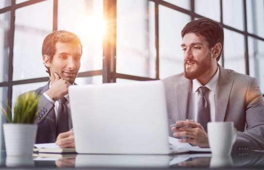 men sitting at a table in a coworking space