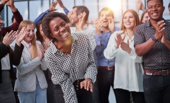 Smiling multiethnic colleagues celebrating common business success or victory in the office.