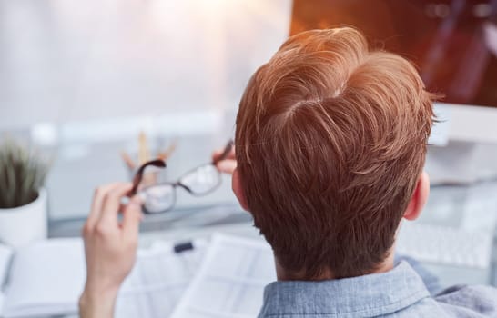 A male manager is reviewing marketing reports for the new campaign