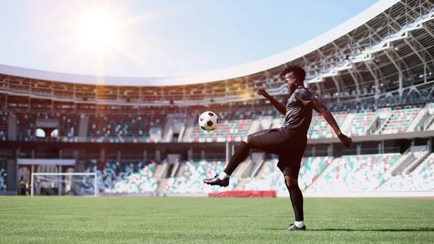 African American man playing football on the stadium field.