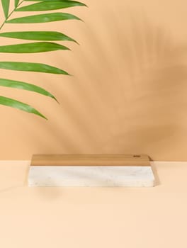 Wooden platform, shadow from a palm leaf on a brown background. Place for displaying cosmetics