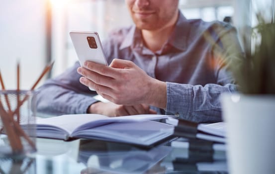 businessman professional executive holding mobile working at desk with smartphone.