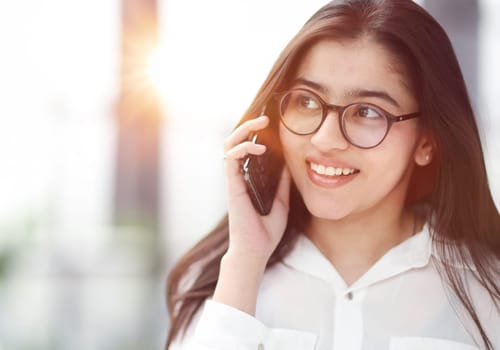 Portrait of young business woman with glasses ofand talking on mobile phone