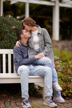 lovely young couple kissing outdoors in autumn. Loving couple walking in nature. Autumn mood. Happy man and woman hugging and kissing in autumn. Love. Fashionable couple outdoors. Fashion, people and lifestyle. Stylish couple in autumn outfit.