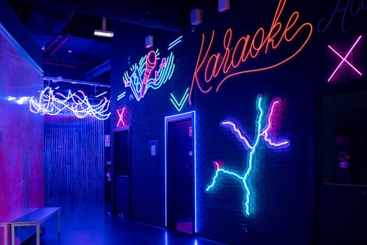 Glowing neon sign with word Karaoke and microphone mounted on brick wall, setting the scene for Karaoke night at illuminated arcade. Entertainment concept.
