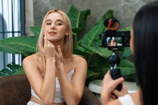 Two beautiful content creator making natural beauty and cosmetic tutorial on green plant leave garden video. Beauty blogger showing how to beauty care to social medial audience by selfie stick. Blithe