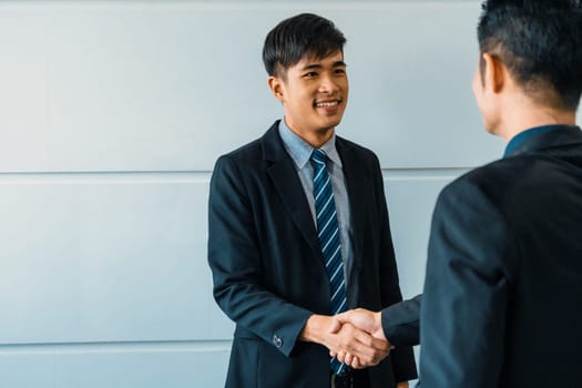 Business people agreement concept. Asian Businessman do handshake with another businessman in the office meeting room. uds