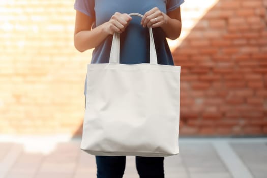 Model hold blank white fabric mockup bag for save environment on street fashion.