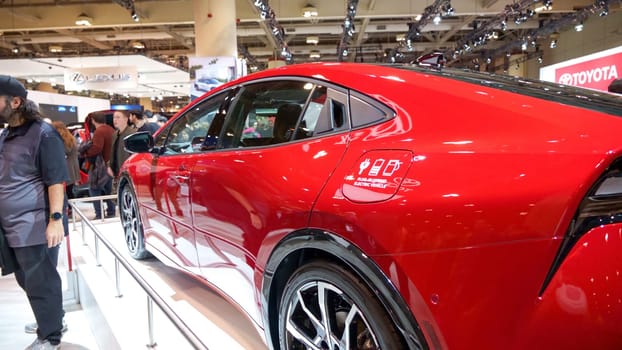 Crowds looking at new car models at Auto show. Toyota Prius car on display. National Canadian Auto Show with many car brands. Toronto ON Canada Feb 19, 2023