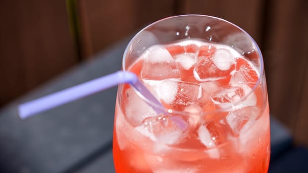 Fresh summer cocktail with strawberry juice and ice cubes. Glass of strawberry soda drink on dark background. Fresh strawberry cocktail