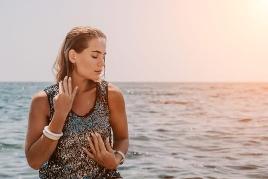 Woman travel sea. Young Happy woman in a long red dress posing on a beach near the sea on background of volcanic rocks, like in Iceland, sharing travel adventure journey