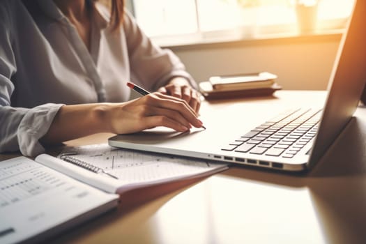 Closeup shot of businesswoman using a calculator and laptop in an office.
