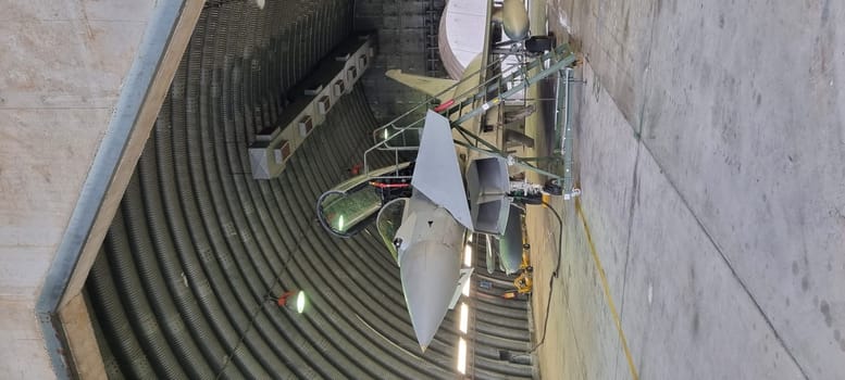 Istrana Italy December 13 2023: Vertical shot of a modern defense aircraft parked in an armored shelter, on alert for immediate takeoff. Perfect for editorial use with ample copy space.