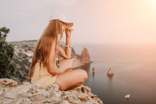 Woman travel sea. Happy tourist taking picture outdoors for memories. Woman traveler looks at the edge of the cliff on the sea bay of mountains, sharing travel adventure journey.