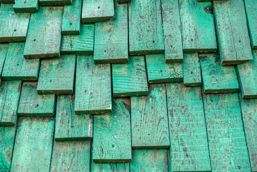 decorative wooden house wall painted green and splashed with red paint