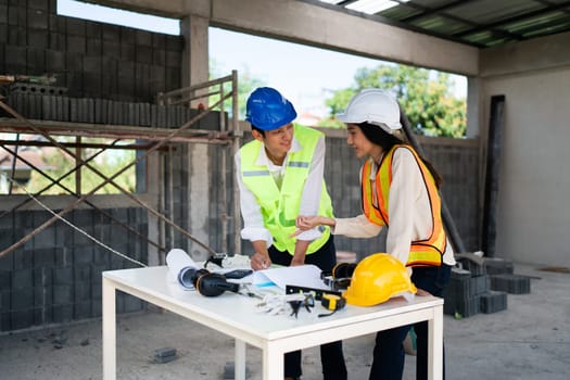 team engineer, foreman, architect meeting for colleagues discussing and checks construction blueprints at onsite.