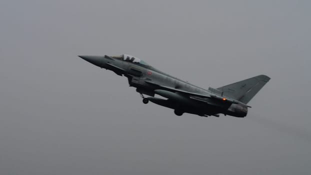 Istrana Italy December 13 2023: Showcasing resilience, a NATO supersonic defense aircraft patrols the grey skies on a day of bad weather, affirming airspace security regardless of conditions.