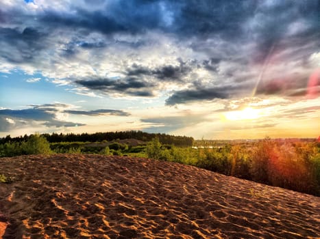 Dramatic and colourful sunset with clouds over the sand dune
