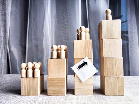 Wooden toy doll on high pedestal and many other figures below. Concept of leadership, which is not available to everyone. Victory and the winner. Talent, Recruitment employee and Successful business