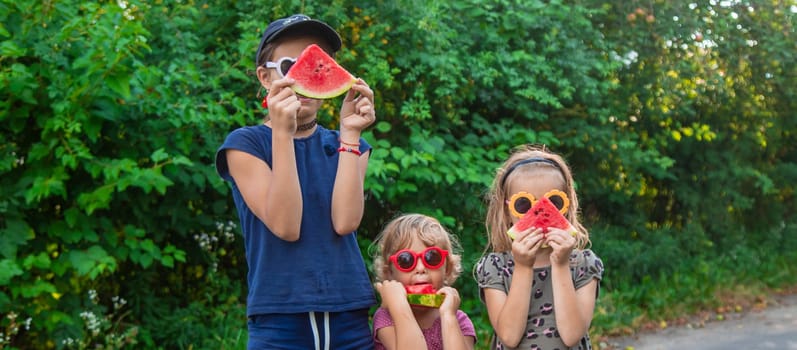 Children in the park eat watermelon. Selective focus. Food.