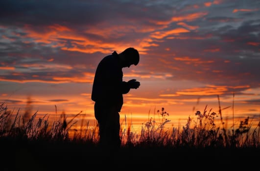 A man stands against a backdrop of a picturesque field as the sun sets, creating a serene and captivating moment in nature