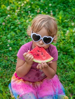 Child girl in the park eats watermelon. Selective focus. Food.