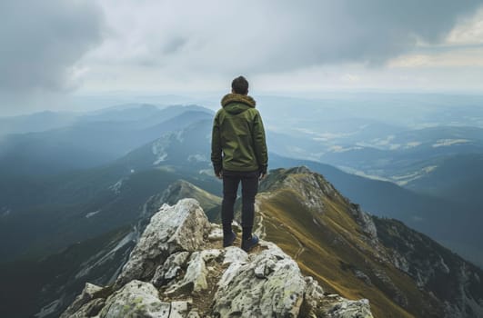 This stunning photo captures a person standing triumphantly at the peak of a towering mountain, surrounded by breathtaking scenery