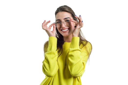 Young charming smiling woman in glasses yellow clothes on white isolated background, female surprised amazed looking at the camera
