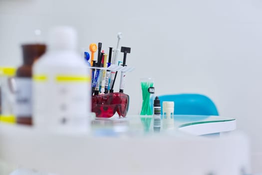 Kyiv UA, 31-07-2019. Close-up of working desk in dentist office with dental composite sealing materials resins, various professional dental instruments tools and medicines