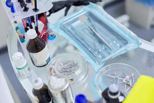 Kyiv UA, 31-07-2019. Close-up of working desk in dentist office with dental composite sealing materials resins, various professional dental instruments tools and medicines