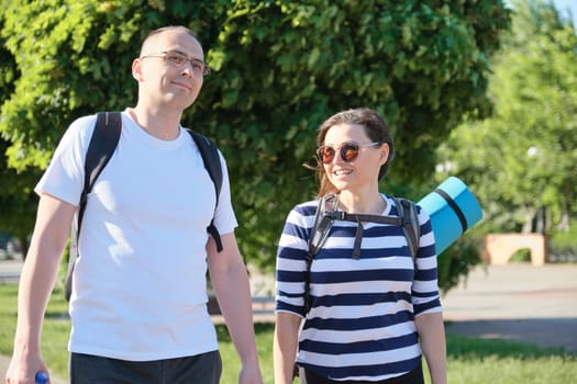 Mature couple walking and talking man and woman, people dressed in sportswear going to fitness training, active healthy lifestyle and relationships of age 40 years old people