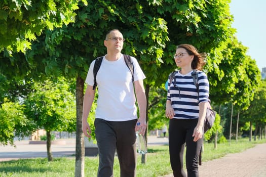 Mature couple walking and talking man and woman, people dressed in sportswear going to fitness training, active healthy lifestyle and relationships of age 40 years old people