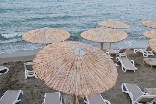 Greece Crete, Heraklion. 12-09-2019. Coast of Greek island Crete, empty sea beach with sun loungers and natural straw umbrellas, late evening after sunset, nobody