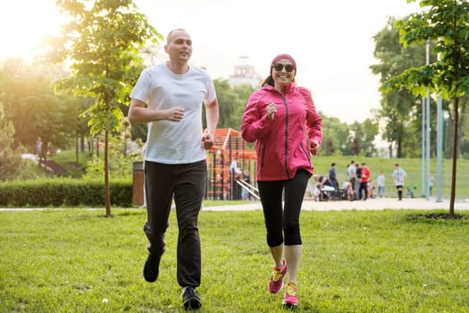 Running smiling mature couple outdoor, sport active lifestyle in middle-aged people.