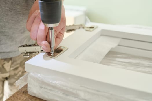 Furniture assembly. Closeup of workers hand with professional tools and furniture details